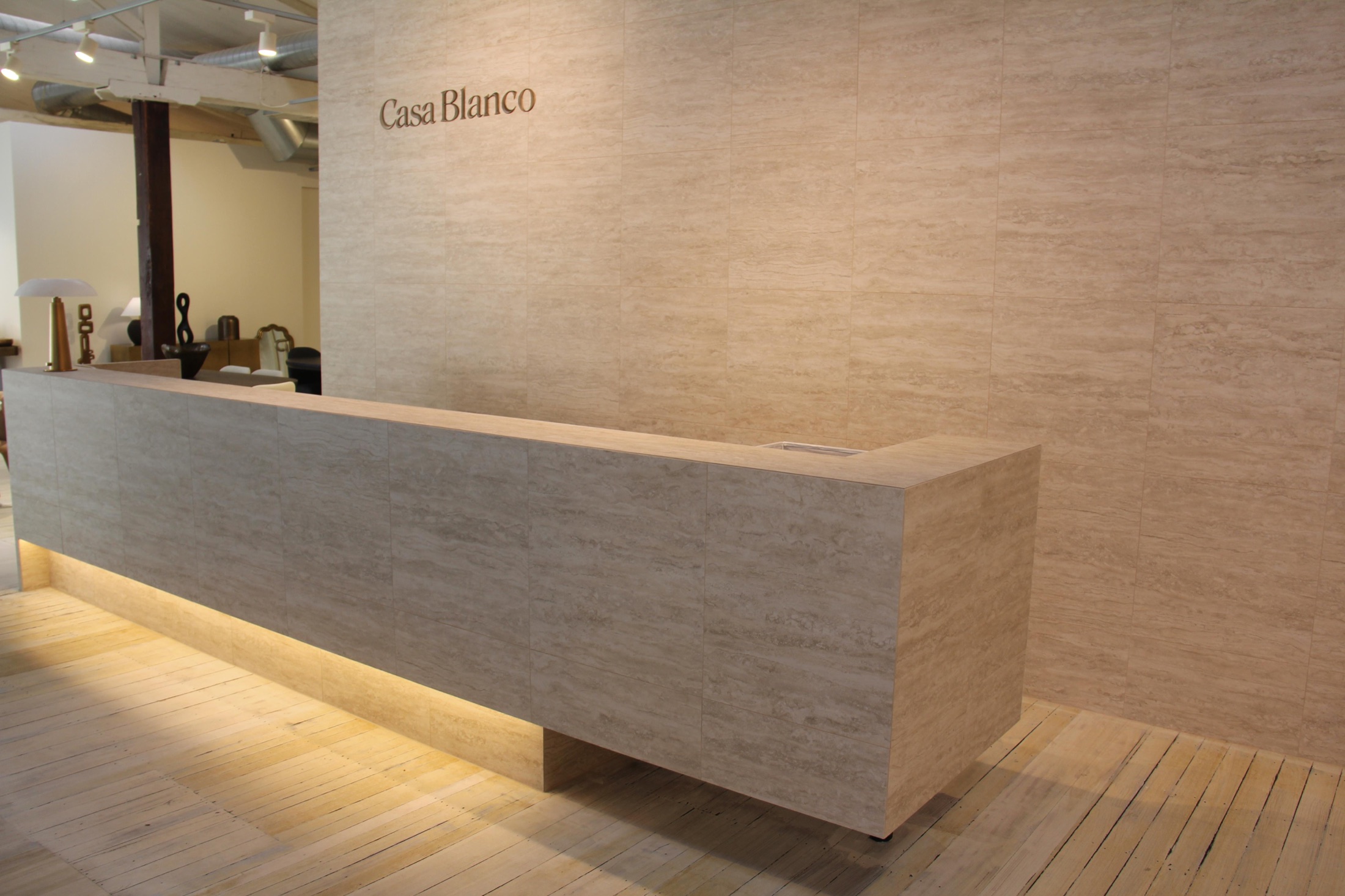 The travertine reception desk and Casa Blanco lettering