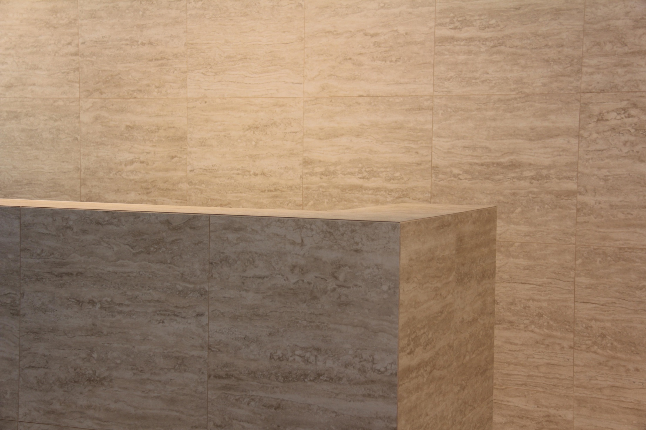 Travertine veining running from the desk face up the wall behind