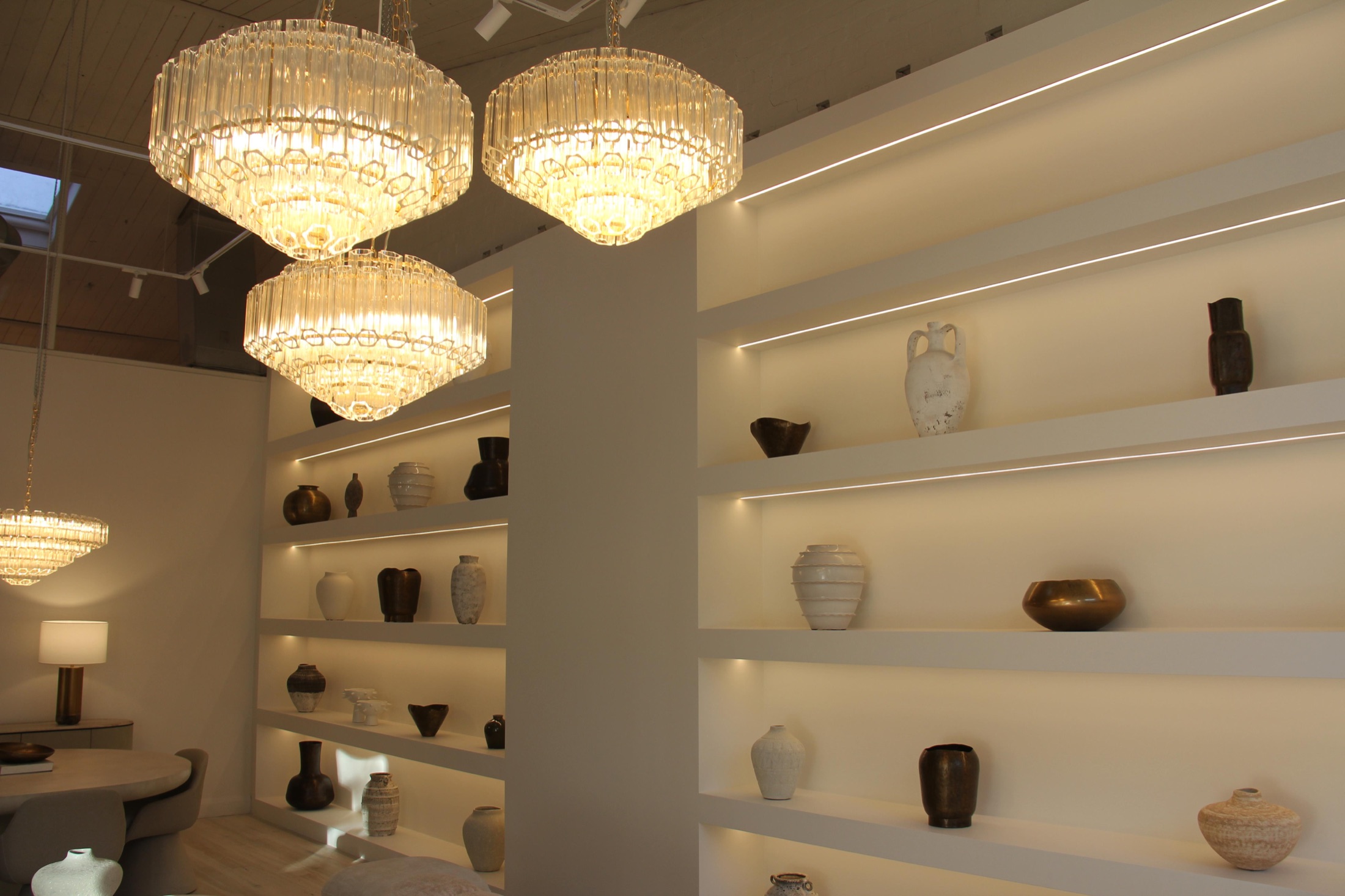 Chandeliers hung against the shelving wall